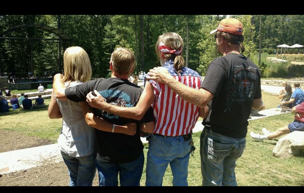 Tommy and family arm in arm at a motorcycle rally